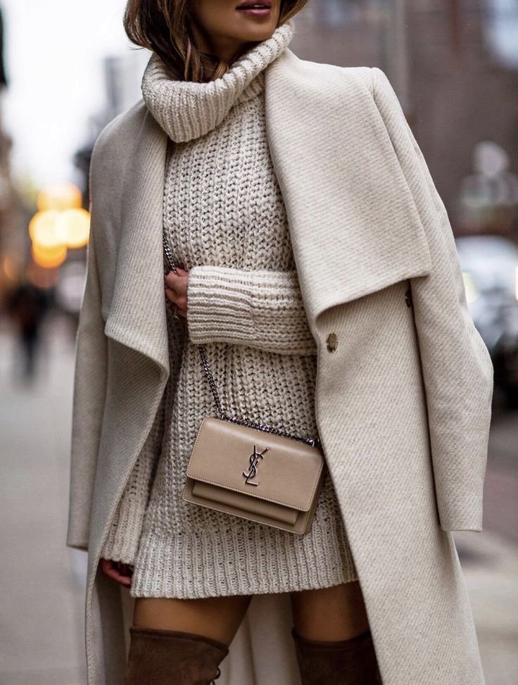 A woman wearing a cream turtleneck dress.