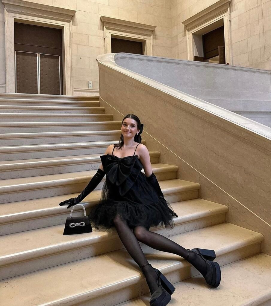 A woman wearing a black ruffled dress.