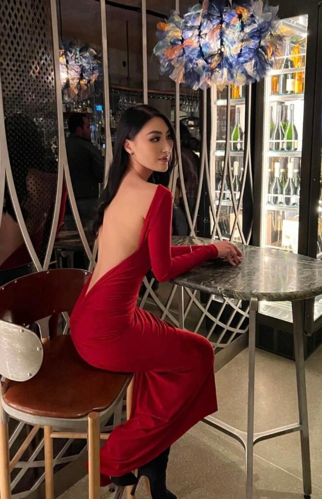 A woman wearing a red backless dress.