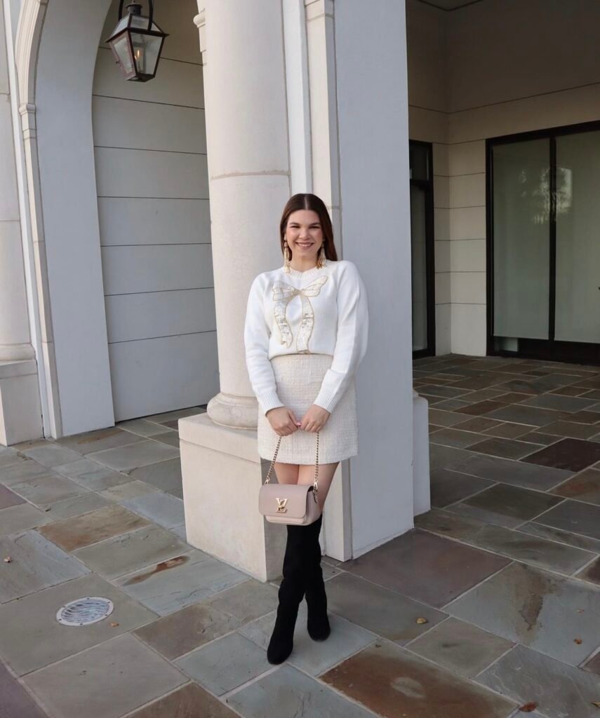 A woman wearing a cream tweed skirt.