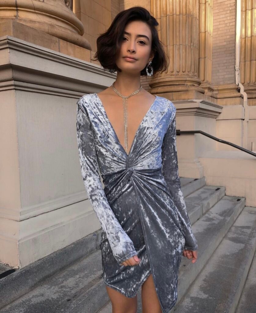 A woman wearing a silver velvet dress.