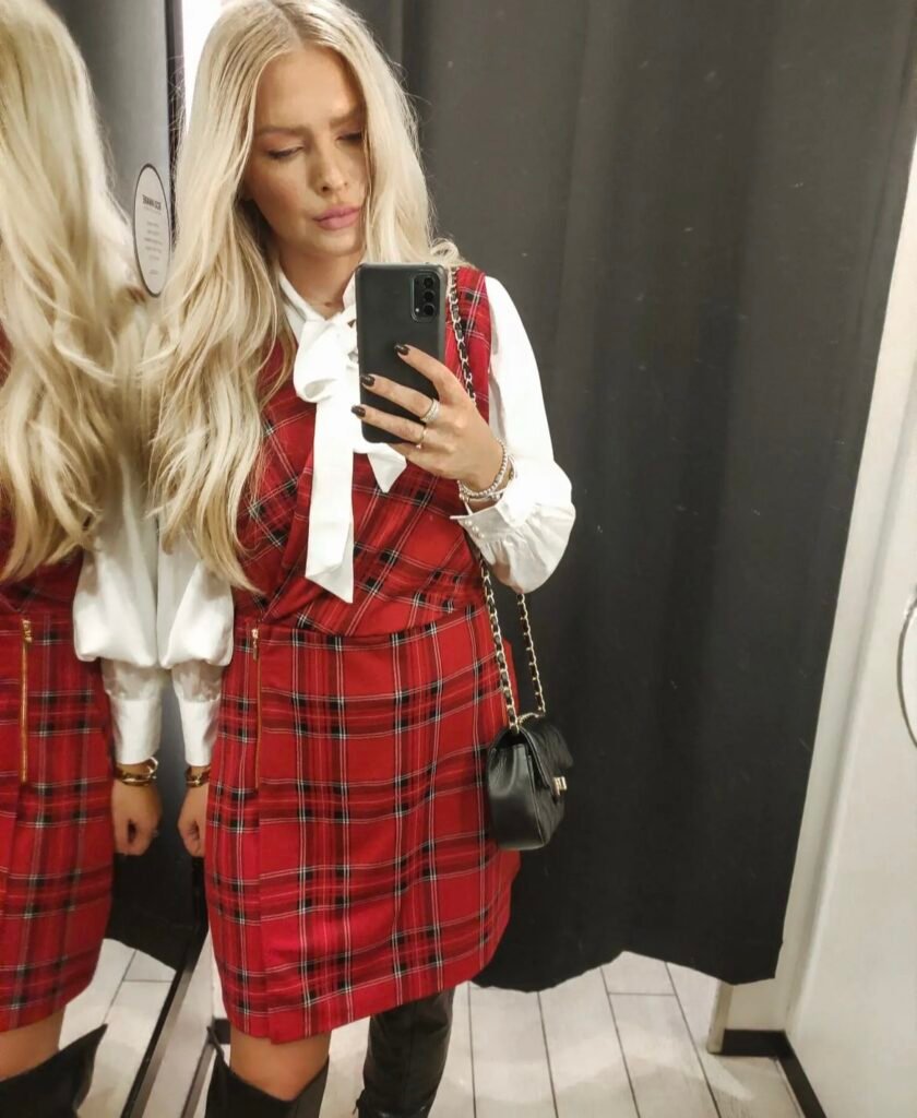 A woman wearing a red tartan dress.