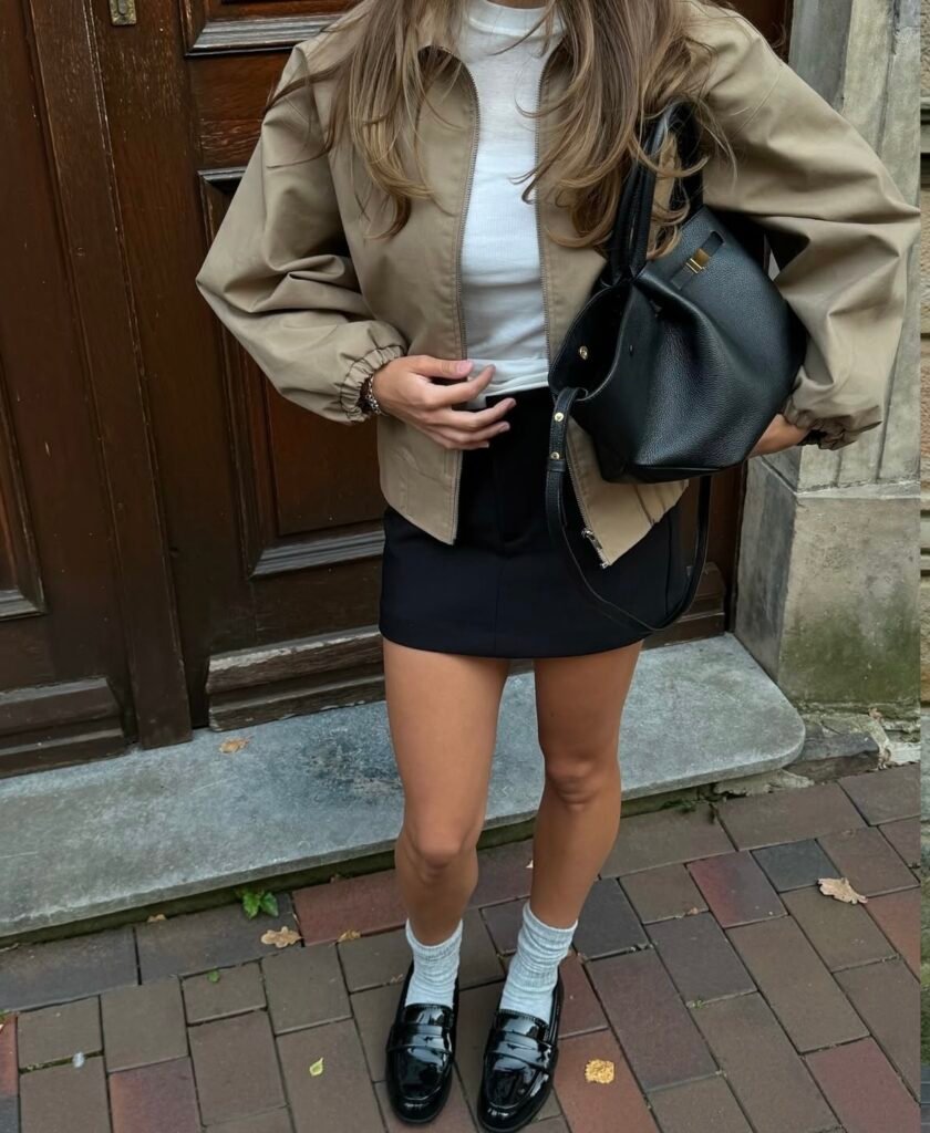 A woman wearing a black skirt and cream jacket.