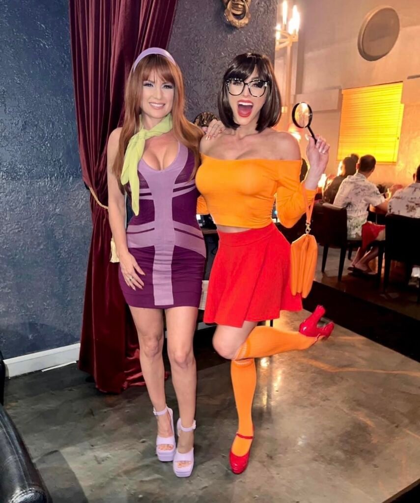 Best friends wearing Daphne and Velma Halloween costumes.