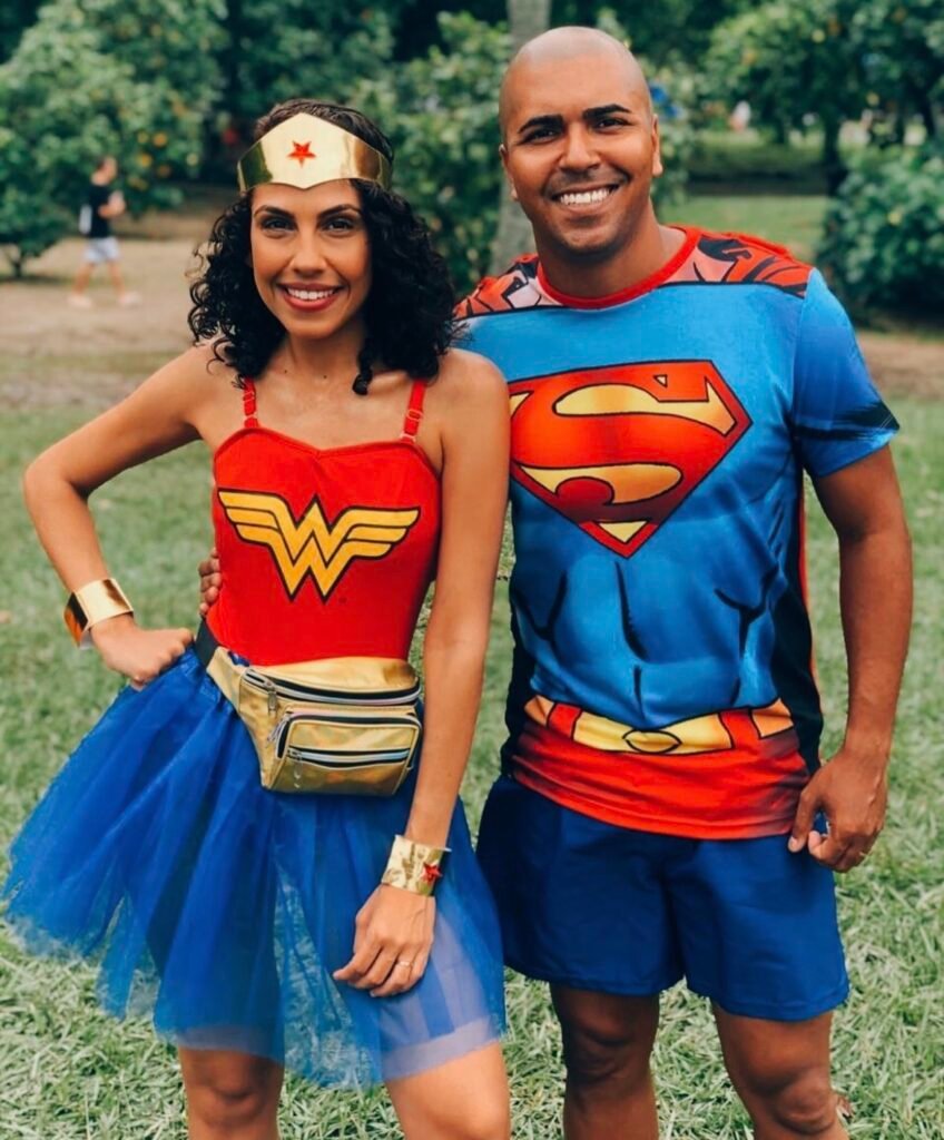 A couple wearing Superman and Superwoman Halloween costumes.