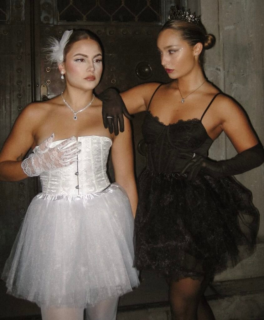 Best friends wearing white swan and black swan Halloween costumes.