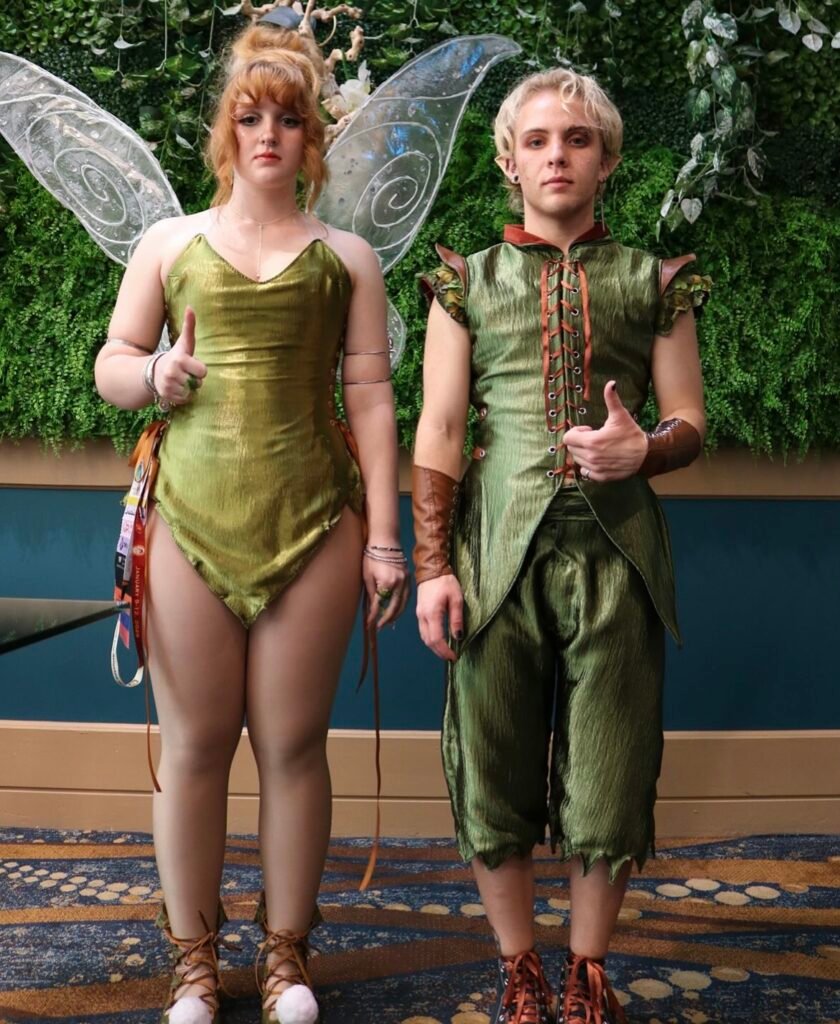 A couple wearing Peter Pan and Tinkerbell Halloween costumes.
