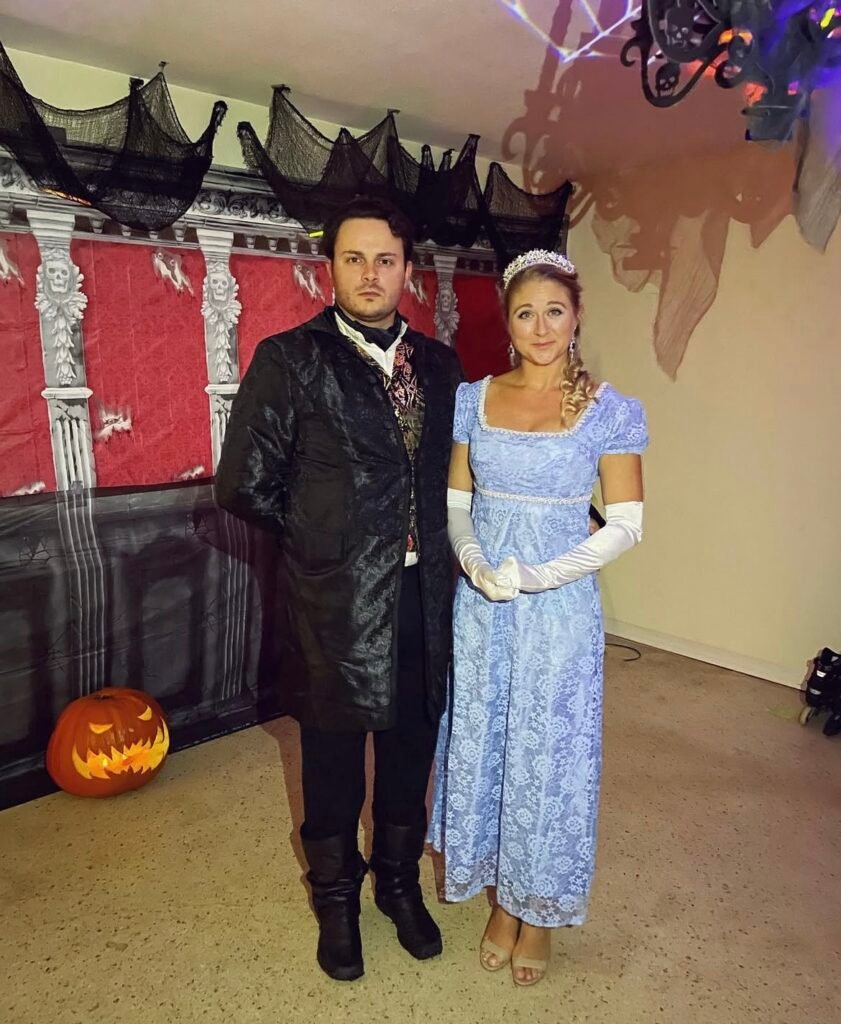 A couple wearing Daphne and Simon Halloween costumes.