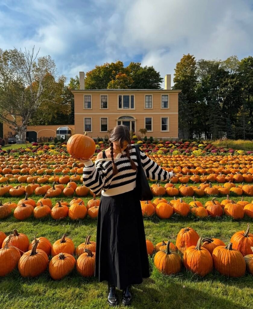 A woman wearing a striped sweater with a black skirt.