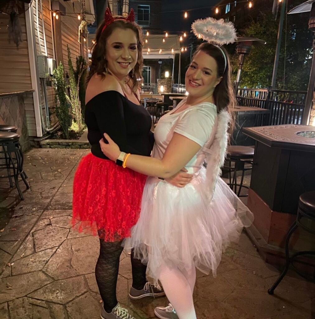 Best friends wearing angel and demon Halloween costumes.