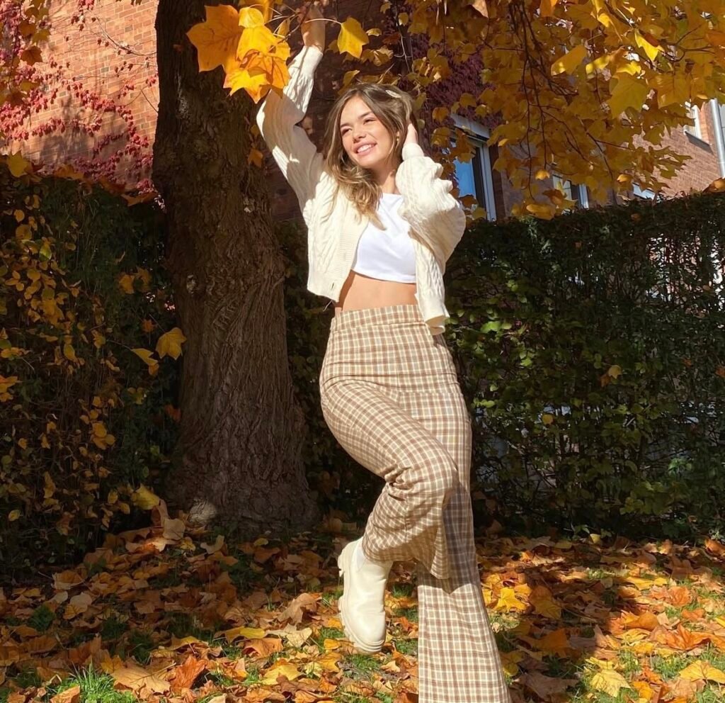 A woman wearing a white top and brown gingham pants.