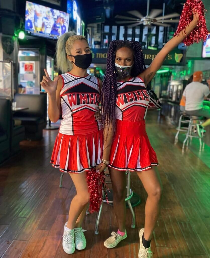 Best friends wearing cheerleader Halloween costumes.