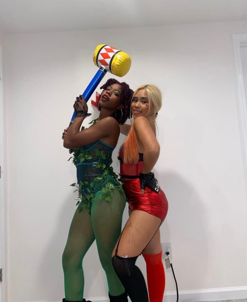 Best friends wearing Poison Ivy and Harley Quinn Halloween costumes.