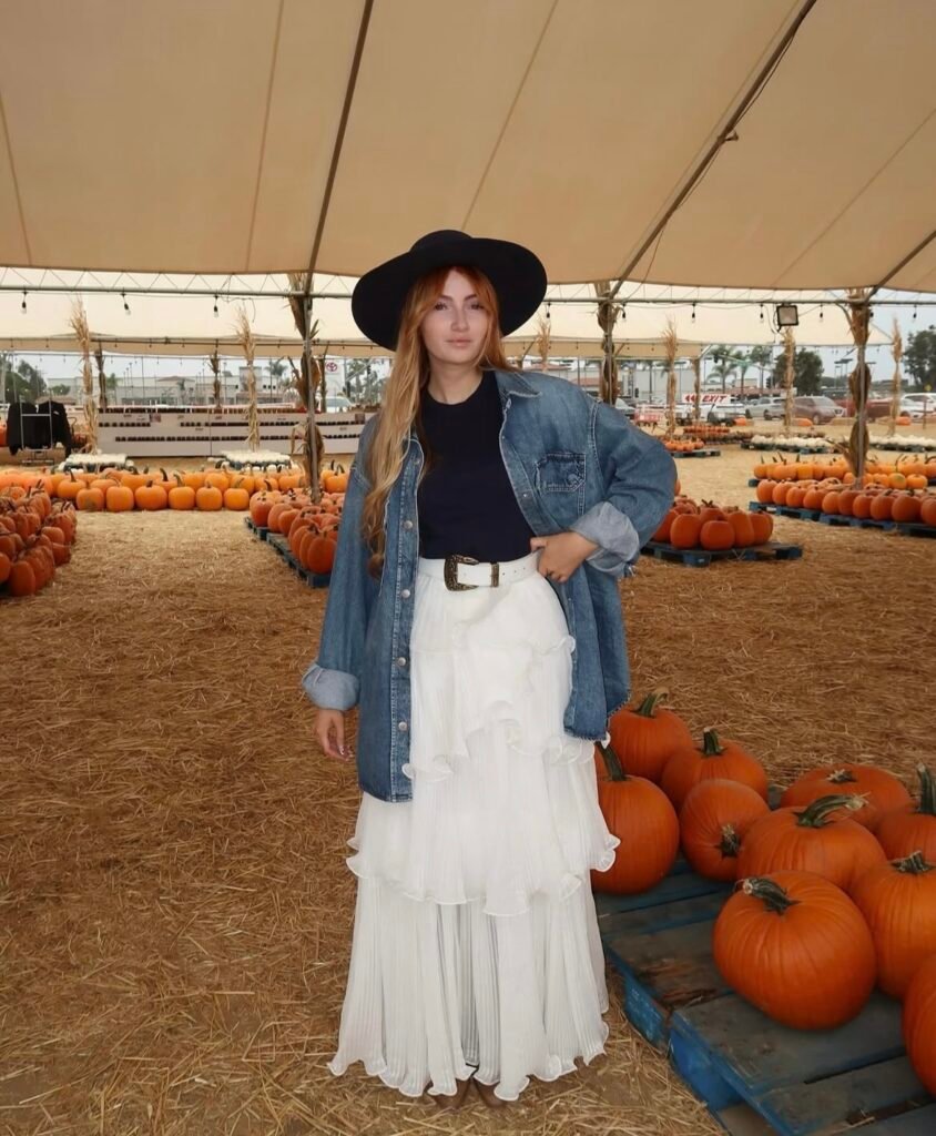 A woman wearing a black top and white skirt.