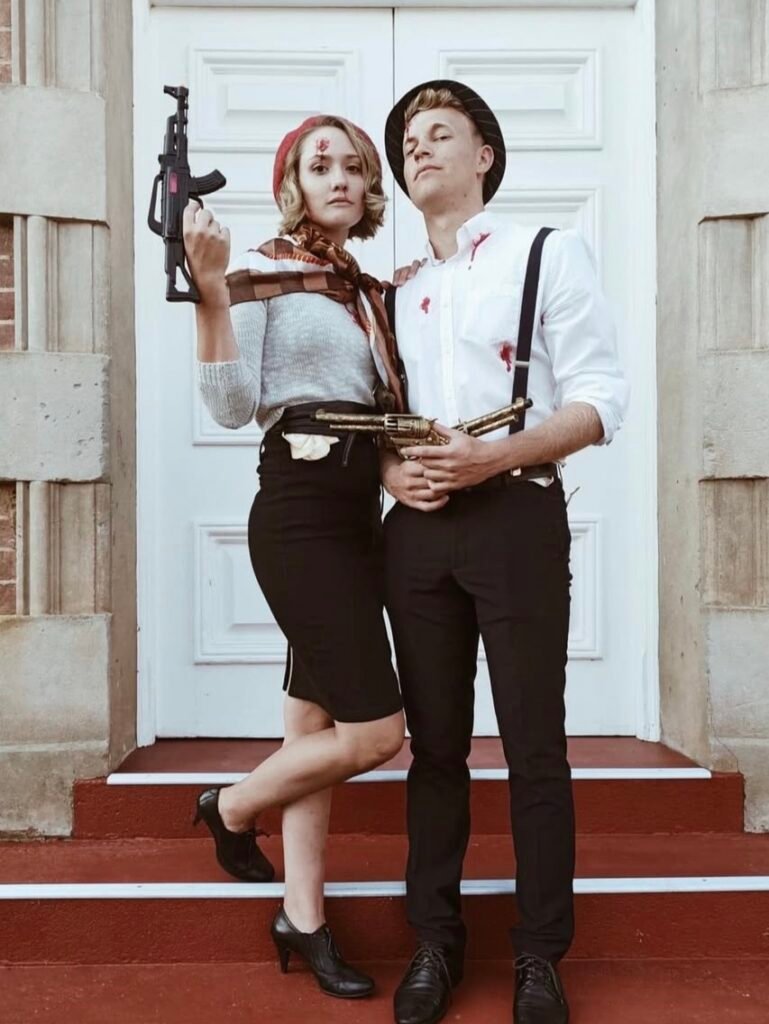 A couple wearing Bonnie and Clyde Halloween costumes.