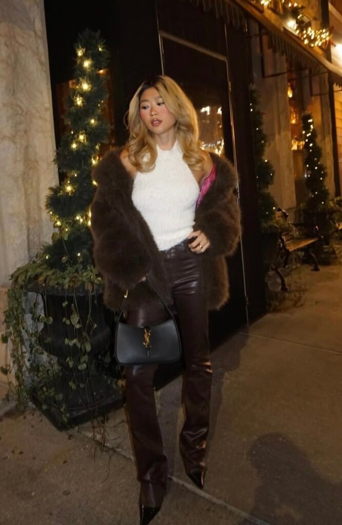 A woman wearing a brown faux fur and faux leather pants.