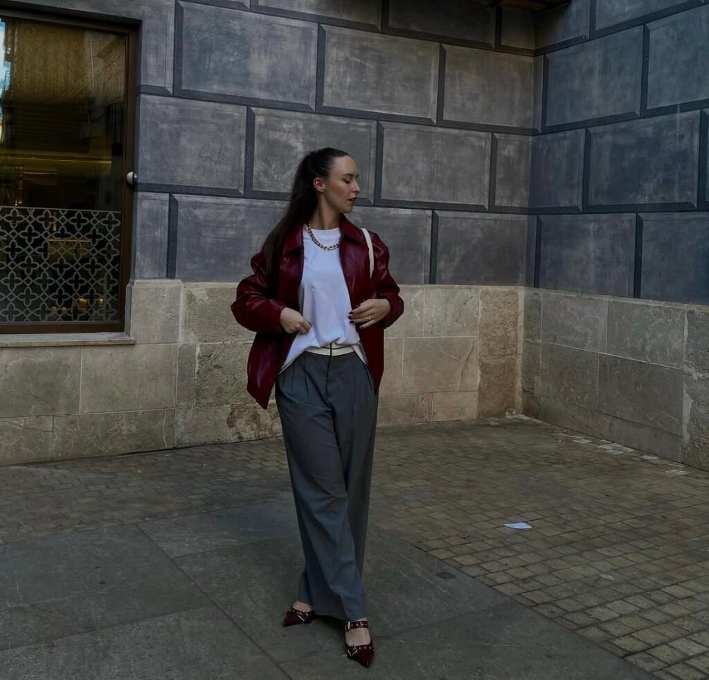 A woman wearing a white top and gray pants.