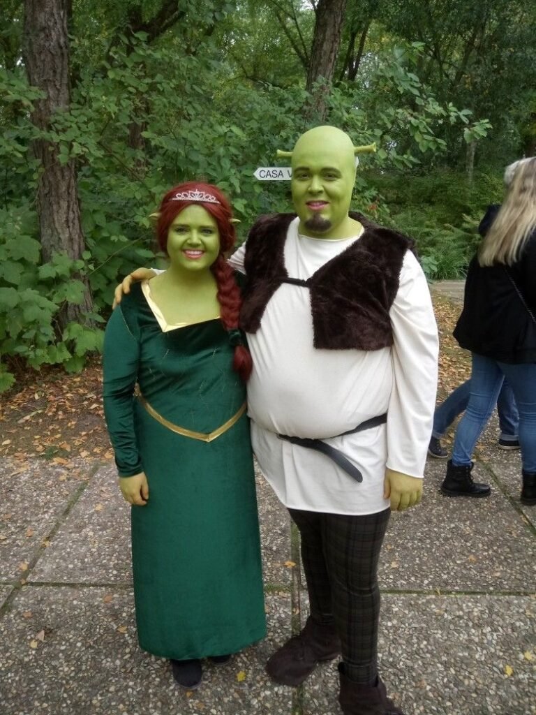 A couple wearing Shrek and Fiona Halloween costumes.