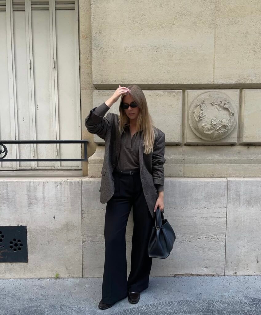 A woman wearing a gray blazer and black pants.