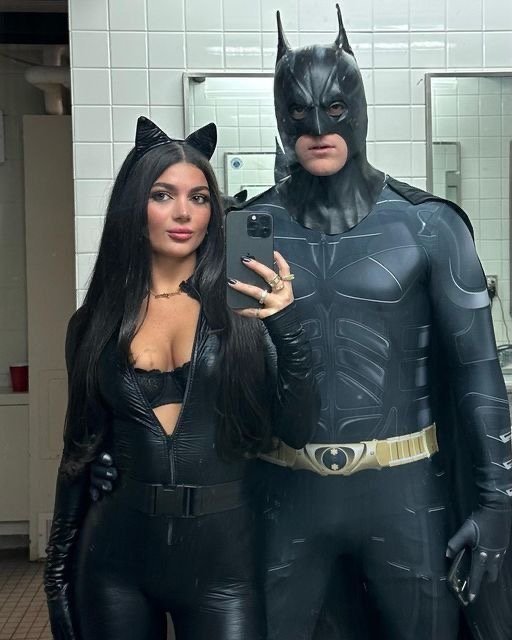 A couple wearing Batman and Catwoman Halloween costumes.