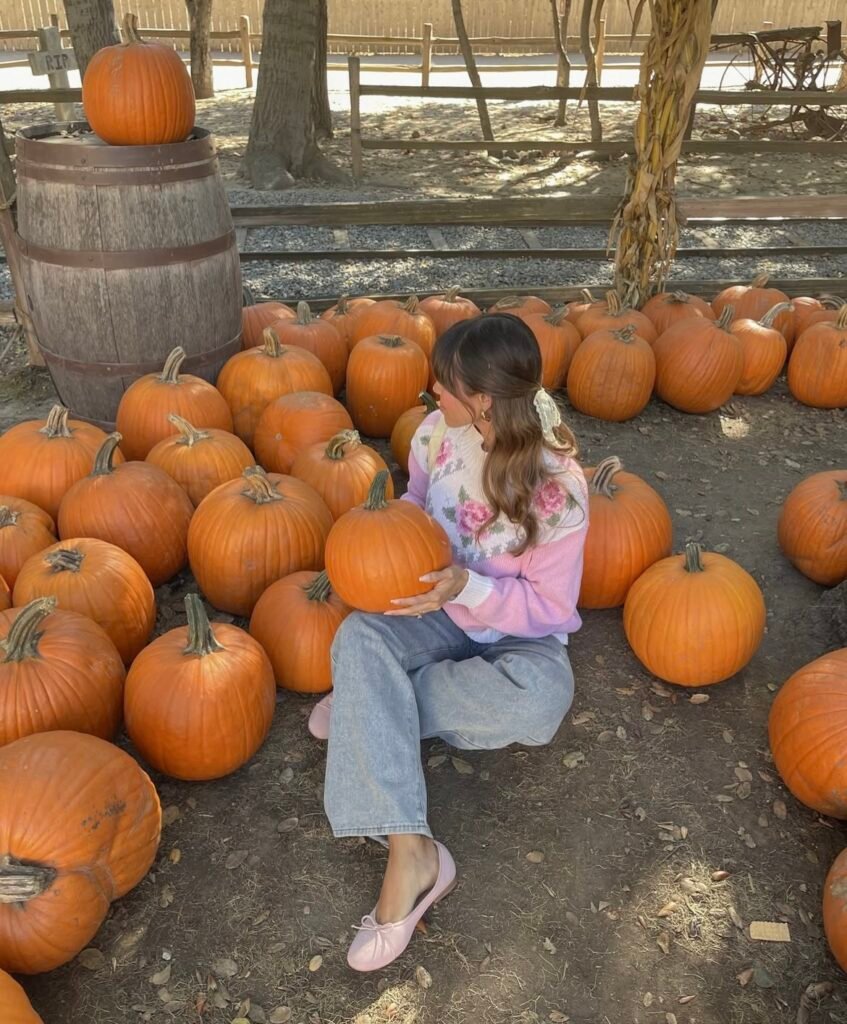 A woman wearing a pink and white sweater with jeans.