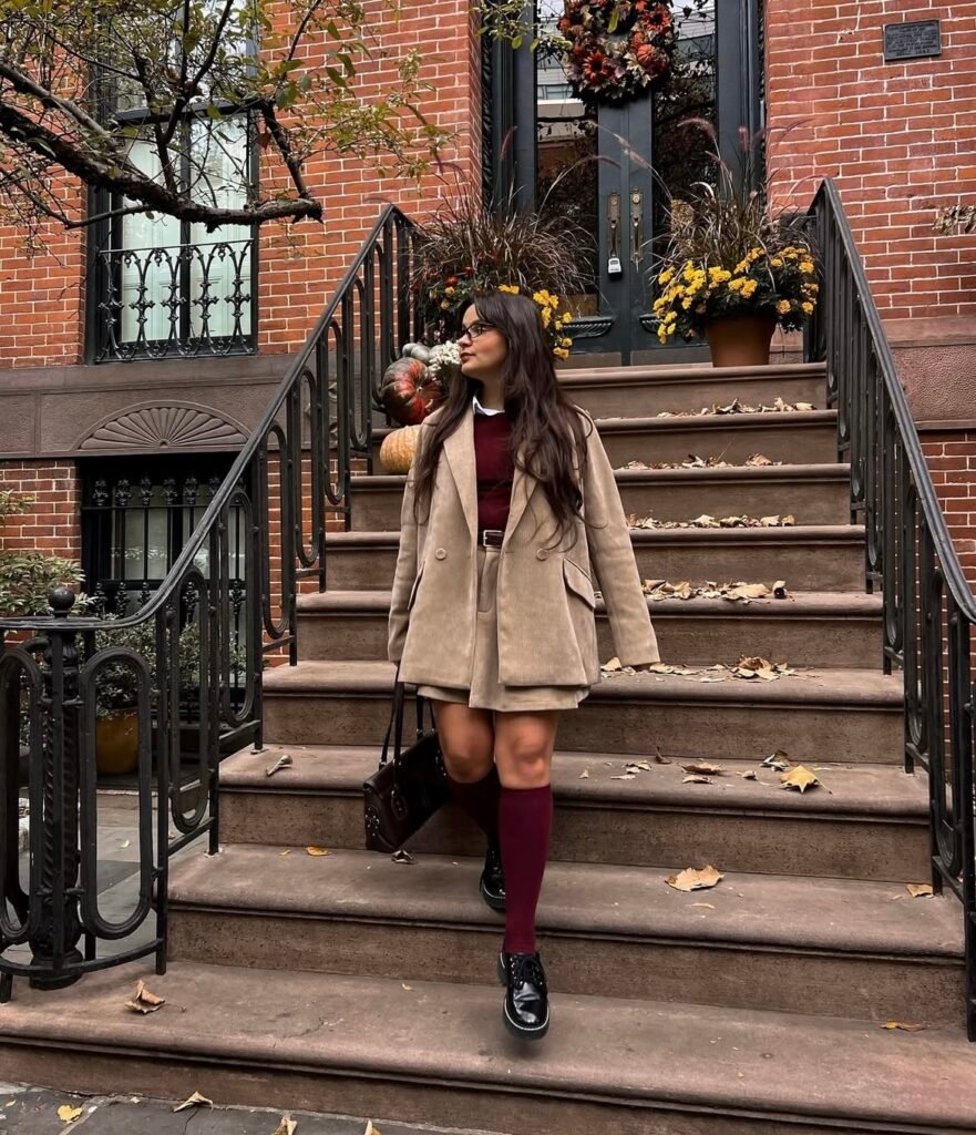 A woman wearing a burgundy and brown outfit.