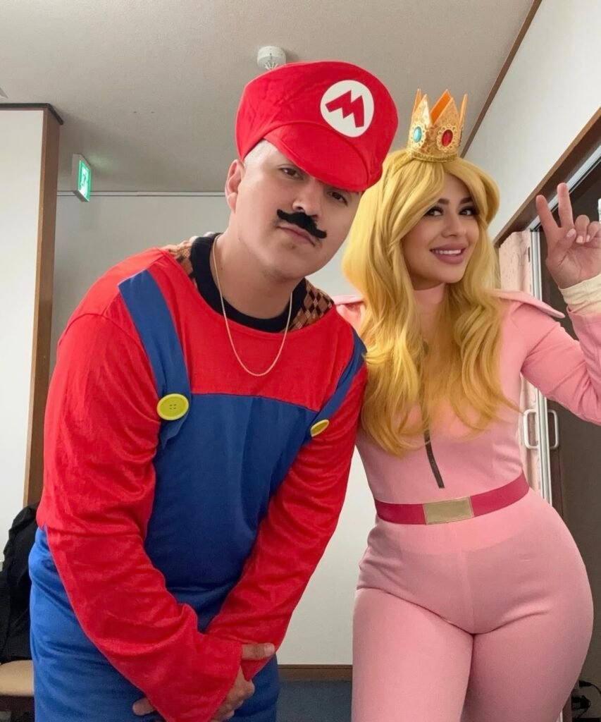 A couple wearing Mario and Peach Halloween costumes.
