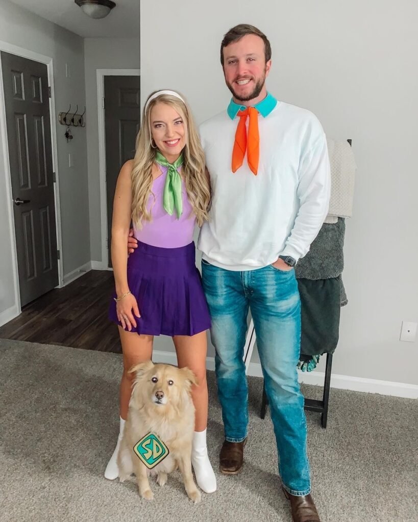 A couple wearing Daphne and Fred Halloween costumes.