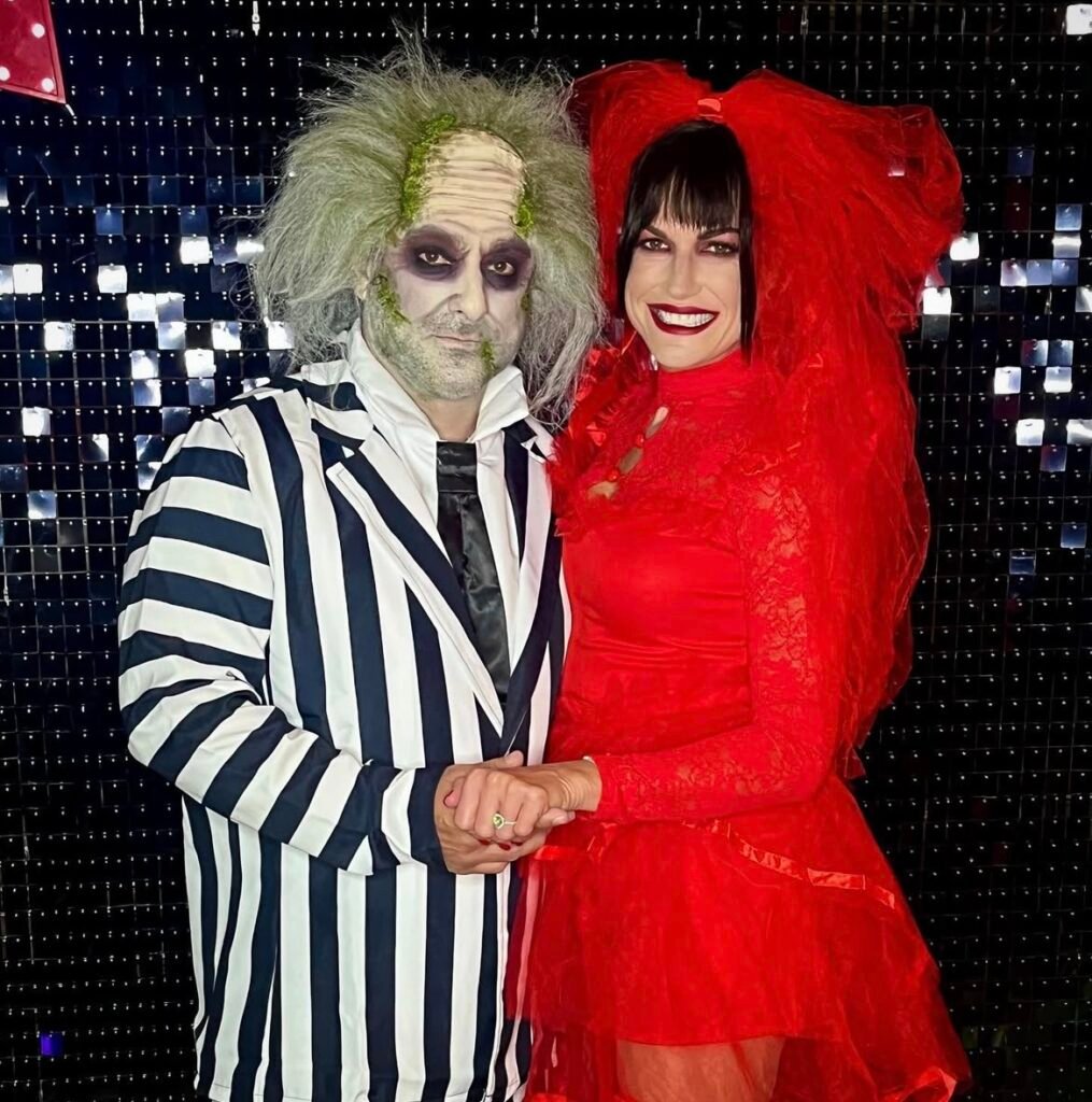 A couple wearing Beetlejuice and Lydia Halloween costumes.