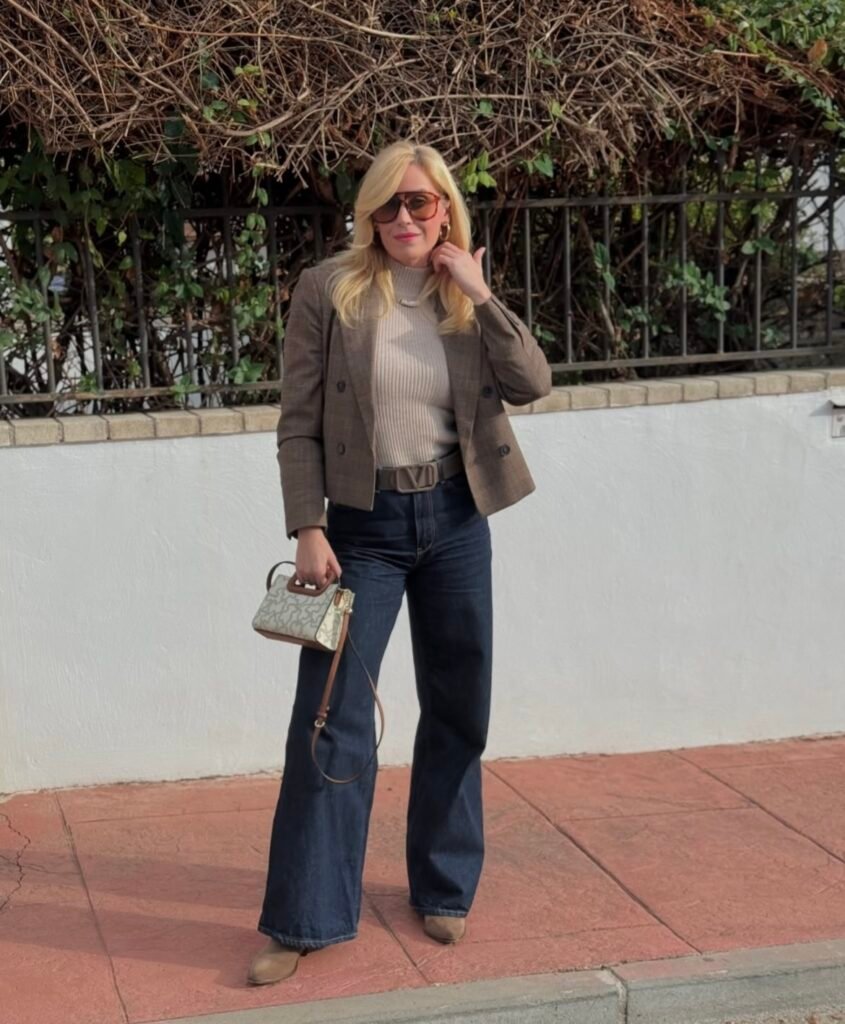 A woman wearing a brown jacket with jeans.