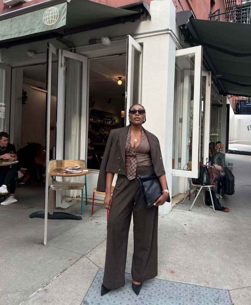 A woman wearing a brown pant suit.